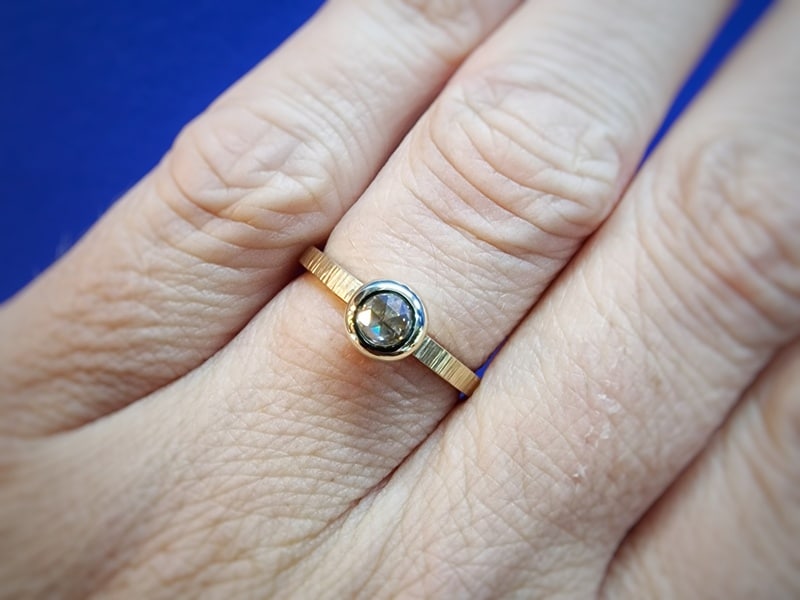 Elegante ring uit de 'Ritme' serie met een roosgeslepen diamant in een boleet zetting. Ontwerp van Oogst Goudsmeden in Amsterdam. Gezien om de vinger