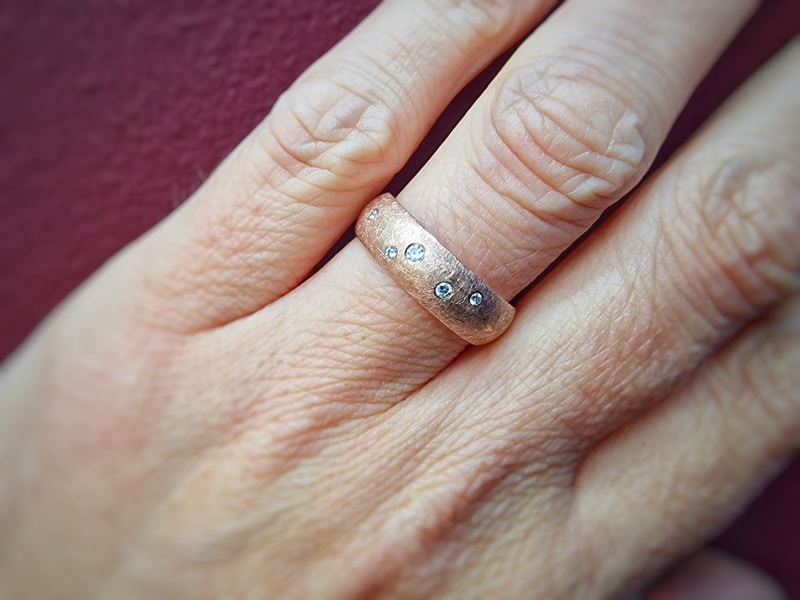 Eenvoud Sterrenhemel ring. Roodgouden ring met diamanten, om de vinger gezien. Uit het Oogst atelier.