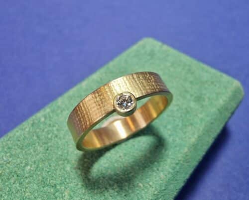 Linnen ring geelgoud met 0,10 ct diamant aan zijkant. Oogst Sieraden in Amsterdam.