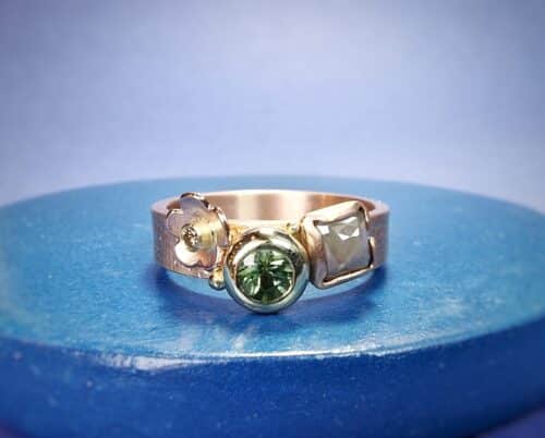 Roodgouden 'Verzameling' ring met speelse mix van linnen textuur en stipjes, naturel diamant, groene toermalijn en bloempje met een briljant geslepen diamant. Oogst Original.