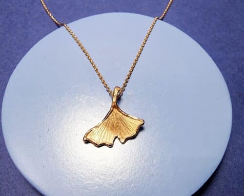 Roodgouden Ginkgo hanger aan een kettinkje. Tijdloos ontwerp uit het Oogst atelier.