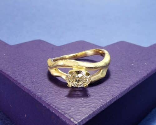 Golf ring geelgoud met 0,55 ovale diamant champagne. Sprankelende blikvanger uit het Oogst atelier.