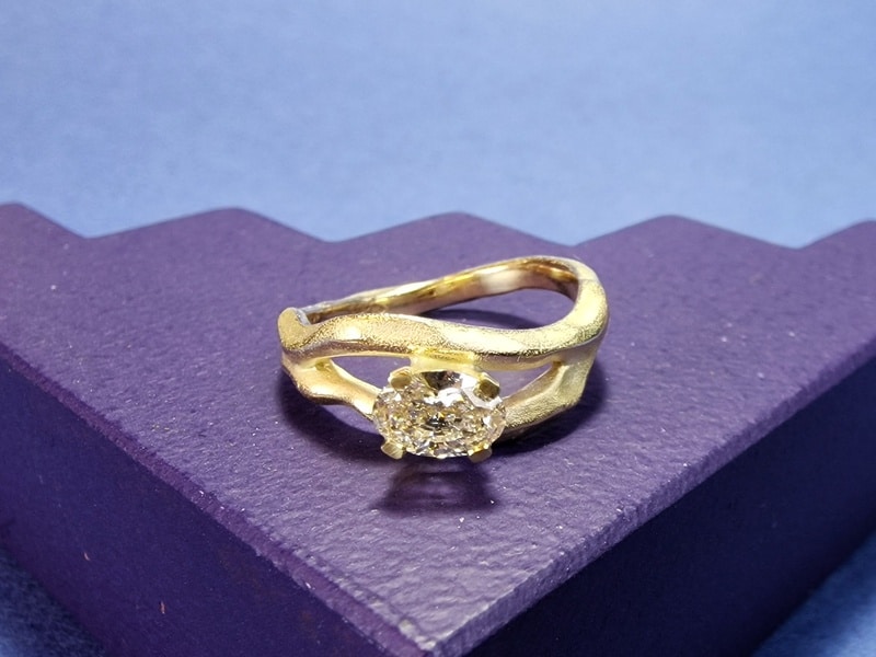 Golf ring geelgoud met 0,55 ovale diamant champagne. Sprankelende blikvanger uit het Oogst atelier.