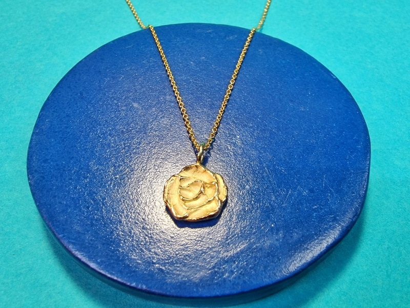Yellow gold pendant Rose inspired by Mackintosh, seen on a chain. Design by Oogst goldsmith studio in Amsterdam