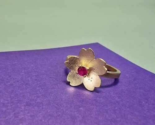Edelsteen ring met geelgouden Sakura, de kersenbloesem, met verfijnde handgravure. Met Robijn, de geboortesteen van juli. Bijzonder stuk van Oogst.