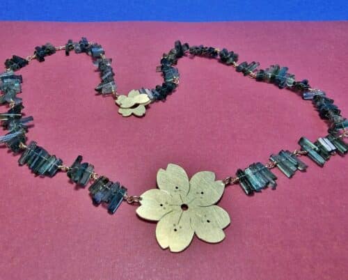 Collier Sakura. De geelgouden kersenbloesem met petrol toermalijn kristallen gecombineerd komt uit de japonais serie van Oogst in Amsterdam.