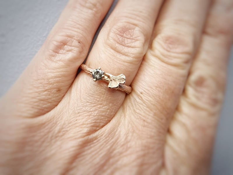 Ring Takje met ginkgo blaadje in roodgoud met salt en pepper diamant. Om de vinger gedragen. Oogst Sieraden ontwerp.