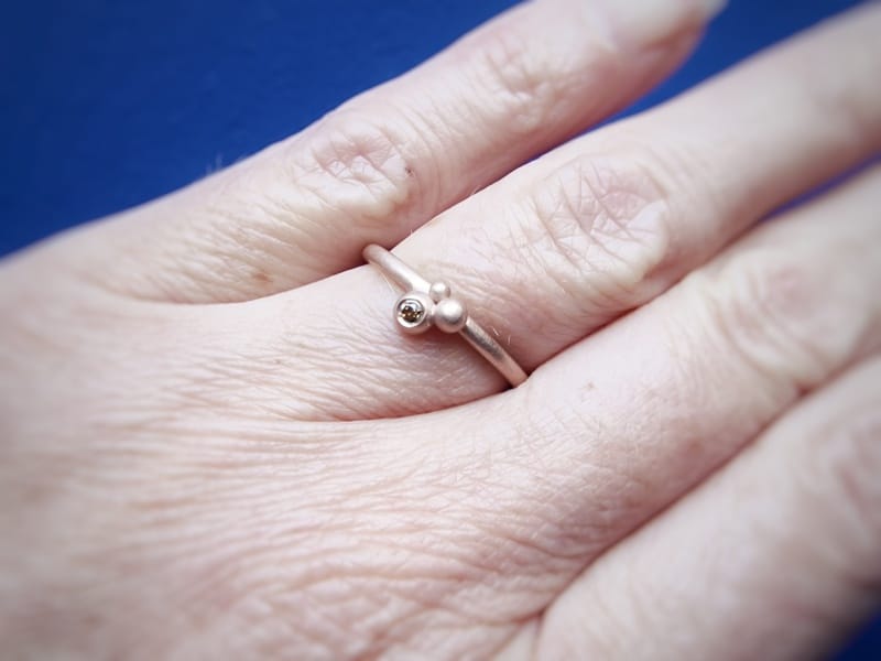Ring 'Bessen' in roodgoud met olijf diamant, om de vinger gedragen. Oogst Original.