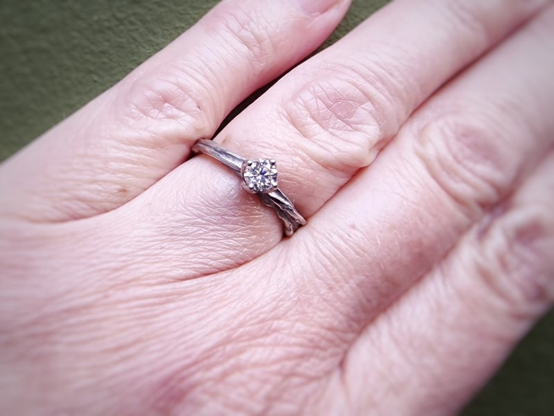 Verlovingsring Twist met diamant. Witgouden textuur ring met een 0,30 ct light brown diamant, om vinger gedragen. Ontwerp van Oogst Goudsmeden.