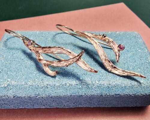 Roodgouden Bladeren oorsieraden met roze saffier. Lange oorbellen uit het Oogst atelier in Amsterdam.