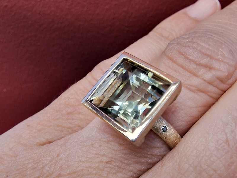 Geelgouden kloeke ring met Prasioliet en groene diamant uit de 'Carré' serie van Oogst. Om de vinger gezien.