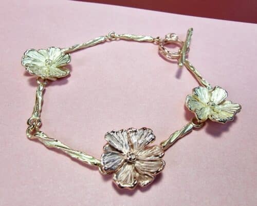 Gouden armband met Cosmea bloemen en twist schakels. Roodgoud met geelgoud. De maandbloem van oktober. Uniek sieraad van Oogst.