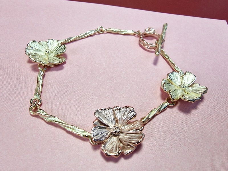 Gouden armband met Cosmea bloemen en twist schakels. Roodgoud met geelgoud. De maandbloem van oktober. Uniek sieraad van Oogst.