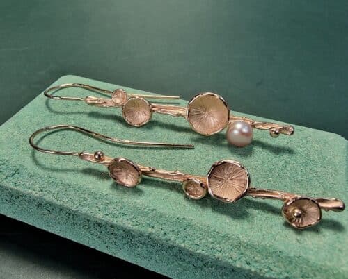 Lange oorsieraden met roodgouden zwammetjes en bouton zoetwaterparel. Elegant en uitgesproken paar van oogst Goudsmeden.