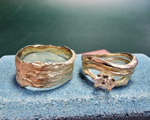 Trouwringen Kust en Golf in geelgoud. Met een 0,55 ct ovale diamant. Stoere trouwringen van Oogst.