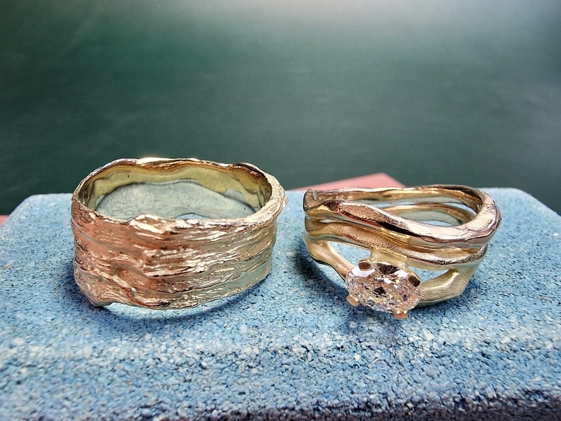 wedding rings 'Wave' & 'Coast'. Yellow gold with sturdy textures and a 0,55 ct oval cut diamond. Standout pair. Oogst jewellery in Amsterdam.