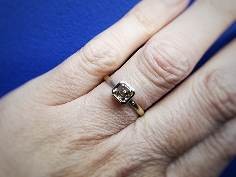 Verlovingsring met asscher cut diamant. Moderne klassieker van Oogst. Om de vinger gedragen.