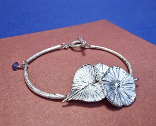 Zilveren armband winde bloemen met blad en een tanzaniet. De maandbloem van september. Stoere armband van Oogst in Amsterdam