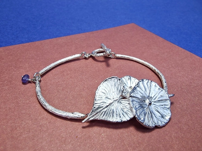 Zilveren armband winde bloemen met blad en een tanzaniet. De maandbloem van september. Stoere armband van Oogst in Amsterdam