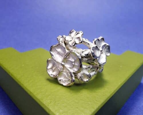 Zilveren takjesring met wulpse bloesems, blaadje en bloemknop uit de Japonais serie van Oogst. Stoer en elegant, een kloeke ring.