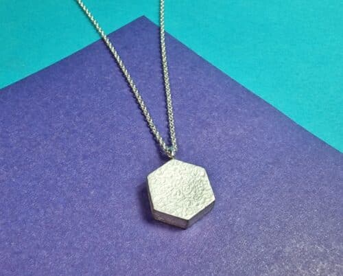 Deze stoere zilveren Hexagon hanger komt uit de 'Kristallen' lijn van de 'Amorf vs Kristallijn' serie. Een kloek sieraad met robuuste textuur. Ontwerp van Oogst.