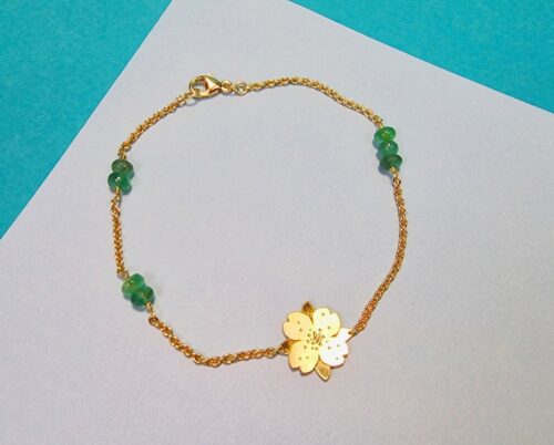 Geelgouden armband met smaragd en een bloem ertussen. Uit de 'In bloei' serie van Oogst Goudsmeden.