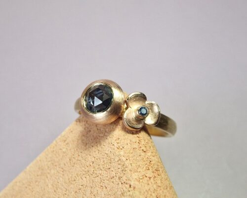 Roségouden ring cluster verzameling. Teal saffier in boleet zetting en ocean blue diamant met bloempje. Oogst Original.