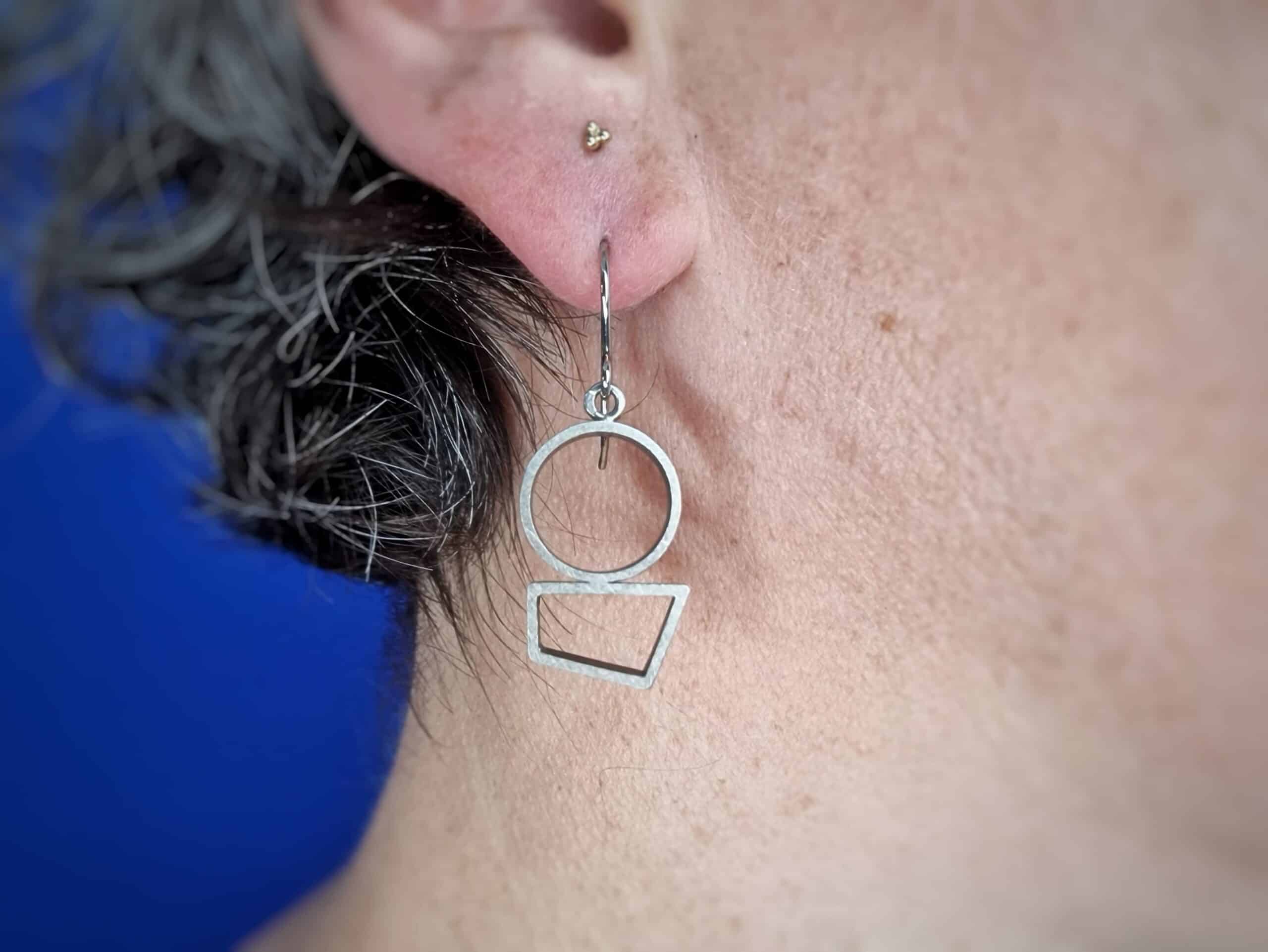 Zilveren oorsieraden Japonais grafische vormen onder elkaar, met krul, in het oor. Oogst Originals.