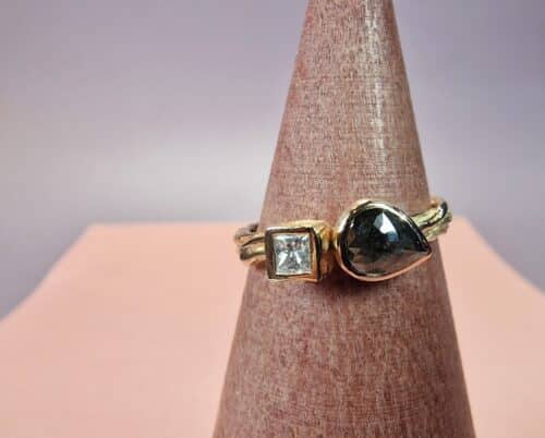 Twist ring roségoud met peervorm roosgeslepen zwarte diamant en princess geslepen diamant in kubus gezet. Verrassende verlovingsring. Uit het Oogst atelier.