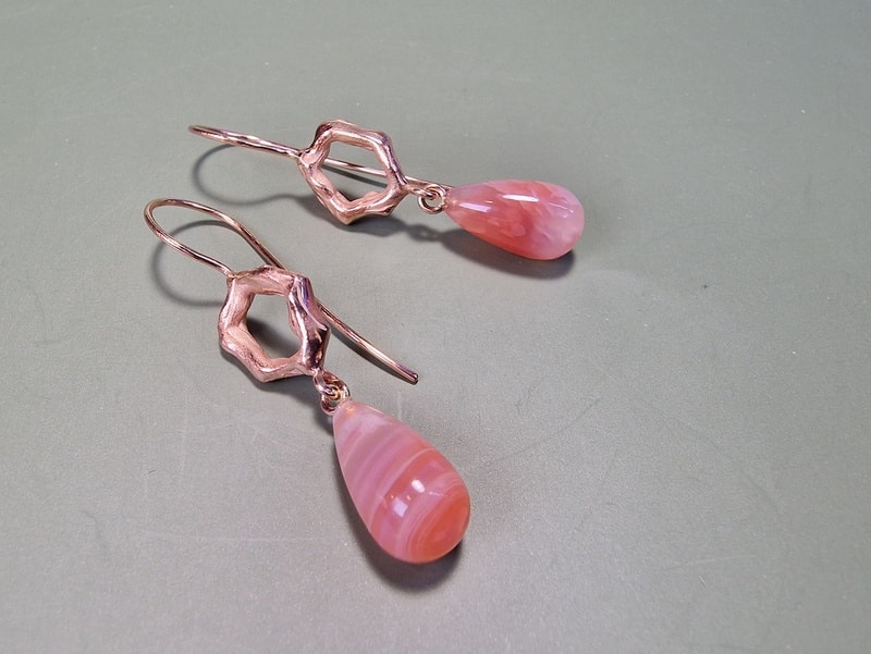 Roodgouden Amorf oorsieraden met agaat pampels en elegante krul. eenmalig paar van Oogst Goudsmeden.