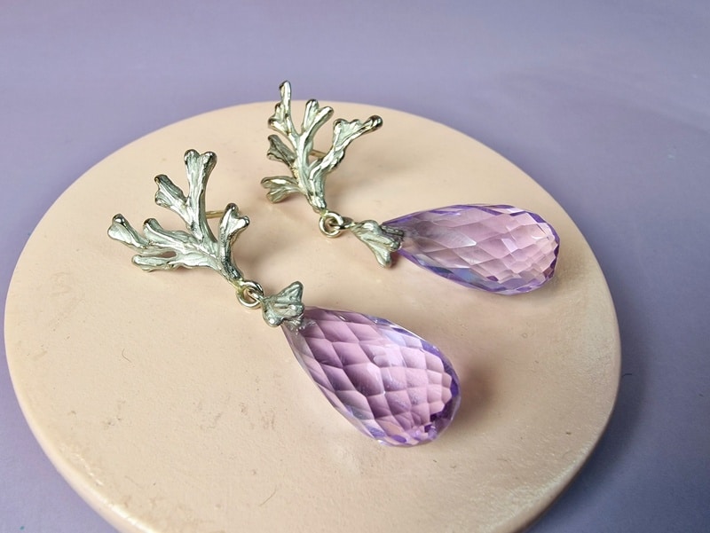 Zeewier oorsieraden in witgoud met briolet geslepen amethist eronder bungelend. Eenmalig paar van Oogst.