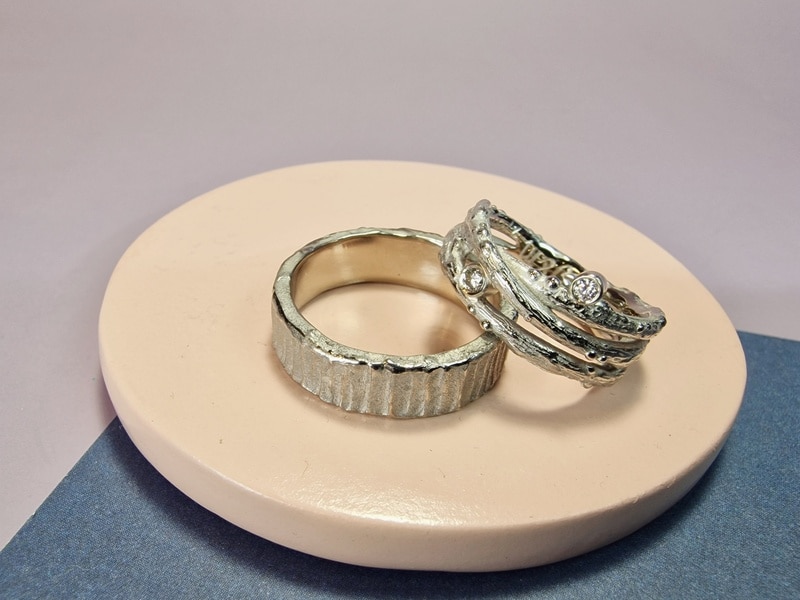 Original white gold wedding rings with sturdy textures. For her gradient twigs with sparkling diamonds, for him a robust look. Bespoke pair created by Oogst.