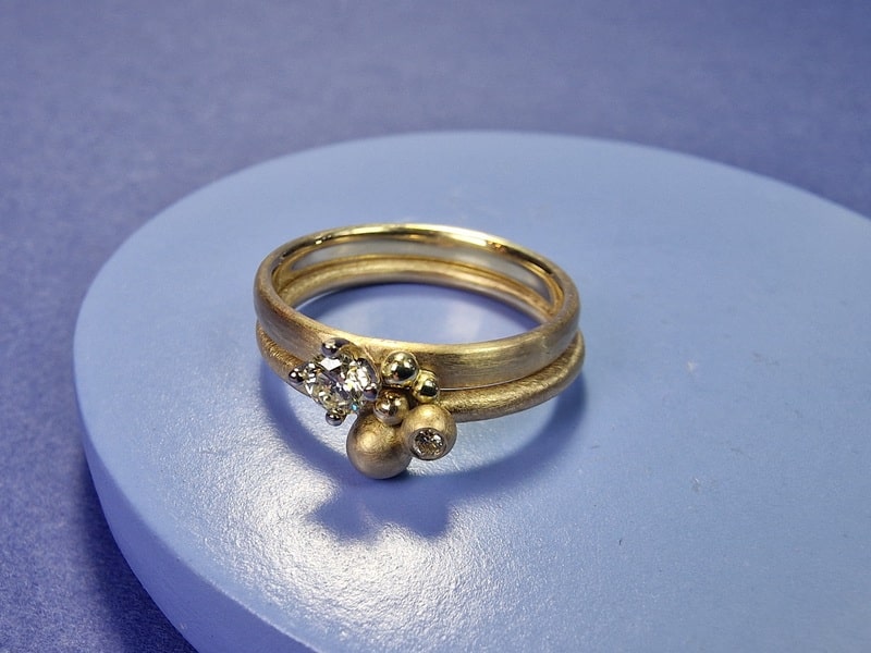 Geelgouden verlovingsring 'Ritme' met 0,16 crt diamant en hamerslag en besjes. Geelgouden 'Bessen' ring met diamant. Leuk om aan te schuiven bij elkaar. Uit het Oogst atelier.