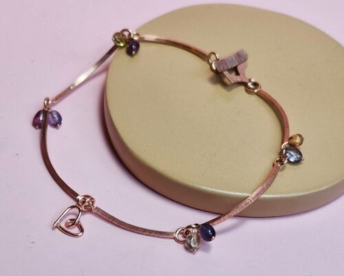 Roodgouden schakel armband met saffier en Mackintosh elementjes. met gehamerde textuur. Elegant ontwerp van Oogst Goudsmeden.
