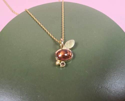 Gouden hanger met rode toermalijn, diamant, besje en blaadje uit de 'Verzameling' serie. Een unieke Oogst Original om elke dag met veel plezier te dragen.